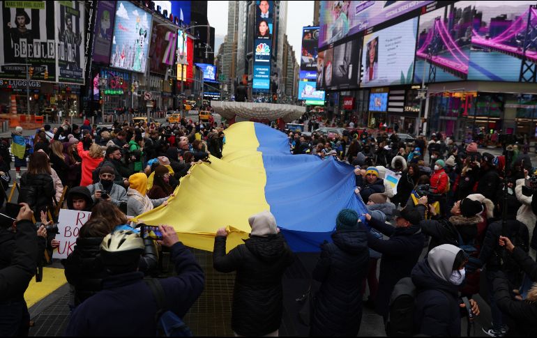 Reunidos en torno a una gigantesca bandera de Ucrania que sostenían unas cuarenta personas mientras la hacían ondear, los manifestantes cantaron su himno y reclamaron apoyo más decidido para su país. EFE / J. Lane