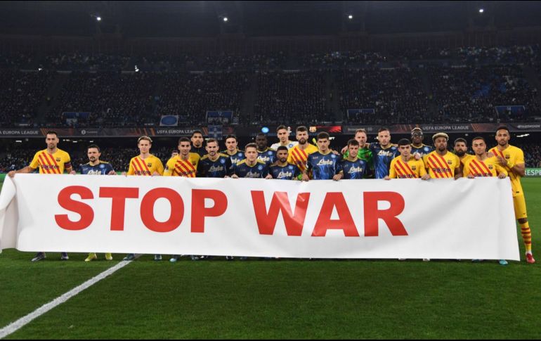 En el partido del Napoli vs Barcelona los jugadores salieron con una manta pidiendo que detengan la guerra. EFE