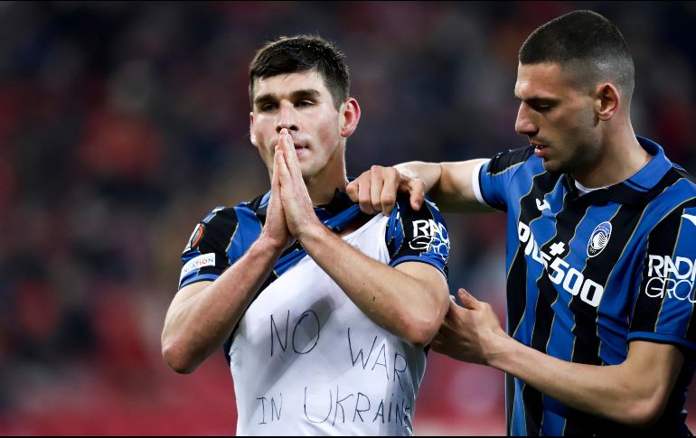 El jugador de Atalanta, Ruslan Malinovskyi (izq.), celebra mostrando una camiseta con el mensaje de 