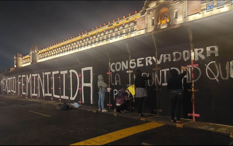 Miembros de grupos feministas escriben consignas en las vallas que protegen Palacio Nacional. SUN/F. Rojas