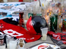 Detalla general de veladoras y ofrendas dedicadas a los atlistas lesionados durante la bronca en La Corregidora. AFP/U. Ruiz