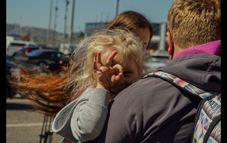 Niña reacciona mientras su familia espera poder entrar a EU. EFE/J. Terriquez