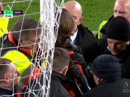 El aficionado, con una camisa naranja con el mensaje de su protesta, corrió hacia una de las porterías y ató su cuello al poste. ESPECIAL