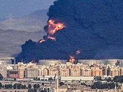 Mientras se llevaban a cabo las prácticas previas a la carrera, en la distancia se veía una espesa columna de humo negro. AFP / A. Isakovic