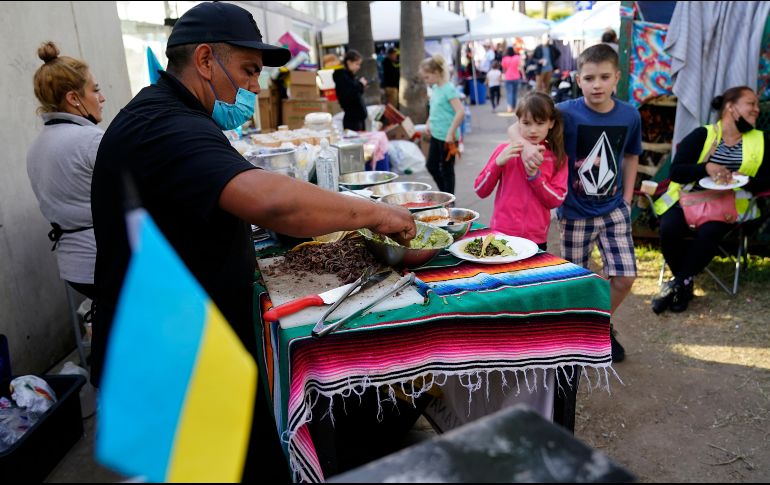 Voluntario mexicano prepara tacos en un campo de refugiados improvisado en Tijuana. AP/G. Bull
