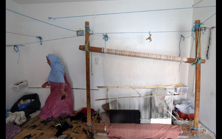 Viejos gorros de lana o calcetines sirven como materias primas para un bello tapiz negro, beige y con tonos dorados. AFP/F. Belaid
