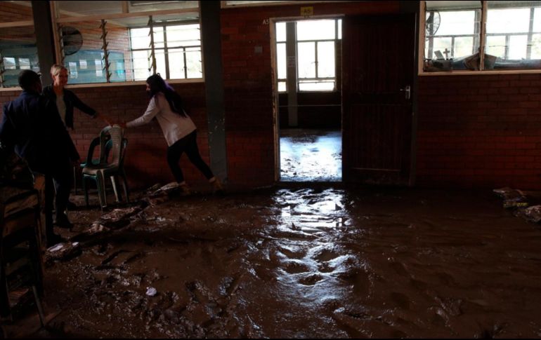 Estudiantes y maestros ayudan a remover el lodo de sus escuelas. AP/STR