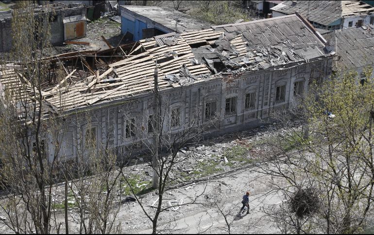 Una persona camina cerca de un edificio dañado en Mariúpol. XINHUA
