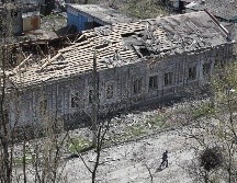 Una persona camina cerca de un edificio dañado en Mariúpol. XINHUA