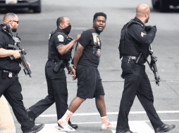 Varios agentes escoltaron a un joven esposado, aunque aún no se sabe si era el culpable de los disparos. ESPECIAL