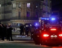 Oficiales investigan el cuerpo de uno de los ocupantes que iba arriba del automóvil que trató de embestir a la la policía. AFP/L. Marin