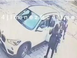 La mujer se apresura a abrir la puerta trasera del vehículo para sacar a su hijo antes de que se lleven en vehículo. ESPECIAL