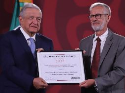 Miguel Malo Serrano, representante de la OMS en México, entrega el galardón a López Obrador durante la conferencia 
