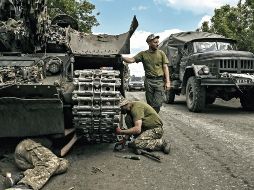 Los miembros de las tropas ucranianas reparan un tanque de batalla principal en la región oriental de Ucrania de Donbás. AFP