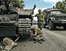 Los miembros de las tropas ucranianas reparan un tanque de batalla principal en la región oriental de Ucrania de Donbás. AFP