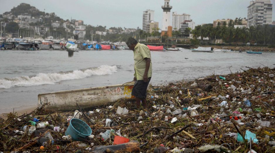 Un hombre permanece en la playa de Santa Lucía, en Acapulco, en medio de basura arrastrada por las lluvias que dejó 