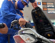 Un asistente bombea gasolina a una moto en Hanói. En todo el mundo, los conductores están repensando sus hábitos y finanzas personales en medio de los precios vertiginosos de la gasolina y el diésel. AP/H. Dinh