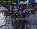 Un motociclista atraviesa una calle inundada en Venezuela, que también registra lluvias por el fenómeno. AP/A. Cubillos