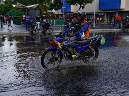 Un motociclista atraviesa una calle inundada en Venezuela, que también registra lluvias por el fenómeno. AP/A. Cubillos
