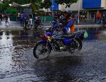 Un motociclista atraviesa una calle inundada en Venezuela, que también registra lluvias por el fenómeno. AP/A. Cubillos