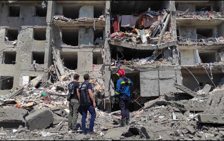 Equipos de rescate contemplan los escombros de un edificio derrumbado por misiles en una pausa de sus tareas. EFE