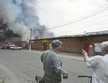Los transeúntes observan cómo se eleva el humo del mercado central de Sloviansk, al norte de Kramatosk luego de ser atacado pos misiles rusos lanzados desde el mar Negro. AFP