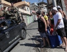 Un grupo de personas lleva en una cobija a una persona presuntamente muerta durante un operativo policial en la favela Alemão, al norte de Río de Janeiro. EFE/A. Coehlo