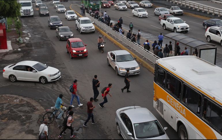 Sin la presencia de agentes viales, los usuarios del transporte público se arriesgan al momento de cruzar hacia la parada del camión que se encuentra en los carriles centrales de la carretera a Chapala, a la altura del Álamo. EL INFORMADOR/A. Camacho