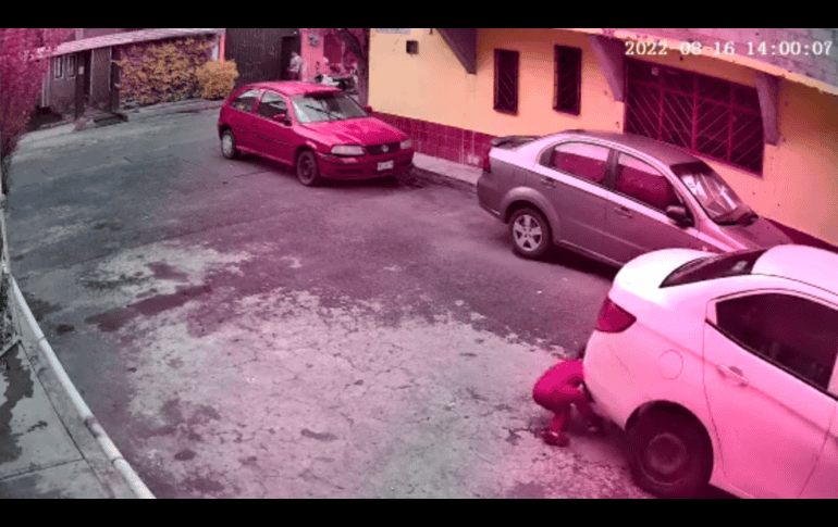 La pareja intenta mover el auto hasta que el conductor avanza para liberar al niño. TWITTER