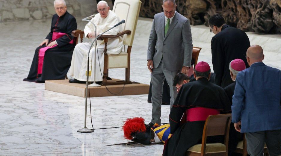 El papa Francisco observa preocupado al guardia, mientras personas a su alrededor intentan reanimarlo. EWTN