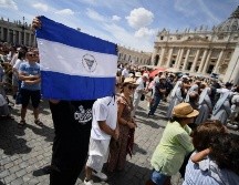 Una persona sostiene una bandera de Honduras en la plaza de San Pedro. AFP / F. Monteforte