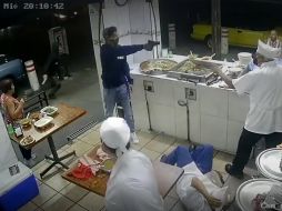Un hombre encapuchado entra y golpea a dos de los taqueros, mientras sus cómplices amagan a los clientes. ESPECIAL