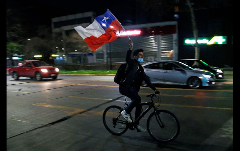 Una persona ondea la bandera chilena tras el rechazo a la nueva constitución. AFP