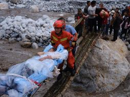 Rescatistas trasladan a sobrevivientes en el poblado de Moxi del distrito de Luding, en la provincia de Sichuan, en el suroeste de China. XINHUA/C. Xueli