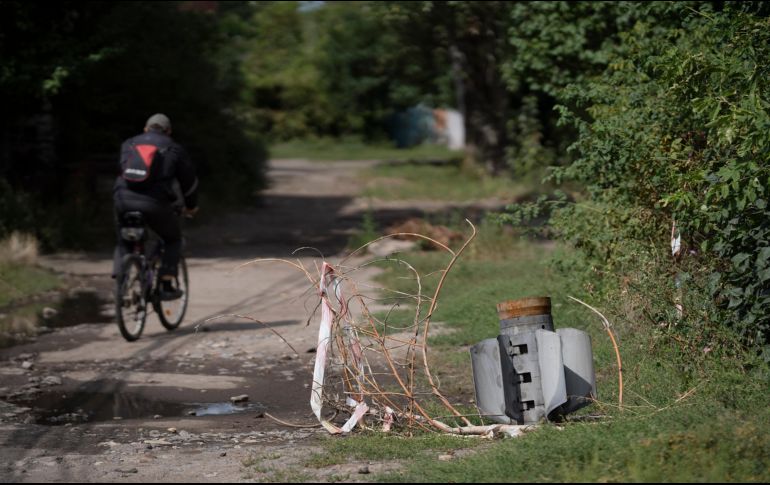 Un hombre pasea a bordo de su bicicleta cerca de los retos de un cohete en Sloviansk, Ucrania. AP/L. Correa