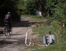 Un hombre pasea a bordo de su bicicleta cerca de los retos de un cohete en Sloviansk, Ucrania. AP/L. Correa