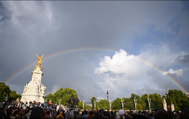 Un arcoíris aparece sobre el Queen Victoria Memorial mientras la gente se reúne frente al Palacio de Buckingham. EFE / N. Hall