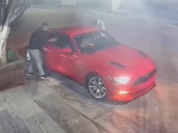 Momento en el que los sujetos rodean el Mustang antes de llevárselo en Avenida Mariano Otero. ESPECIAL