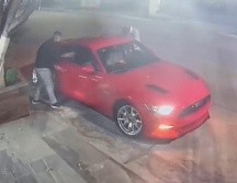 Momento en el que los sujetos rodean el Mustang antes de llevárselo en Avenida Mariano Otero. ESPECIAL