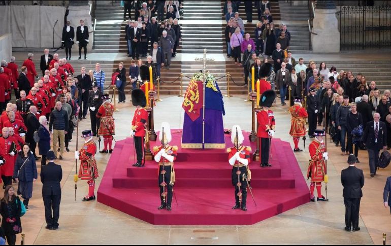 Dentro de Westminster Hall, el féretro de Isabel II yace sobre un catafalco púrpura, en lo alto de un zócalo de cuatro peldaños, cubierto por el estandarte real, la corona imperial y el cetro. AFP / Y. Mok