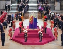 Dentro de Westminster Hall, el féretro de Isabel II yace sobre un catafalco púrpura, en lo alto de un zócalo de cuatro peldaños, cubierto por el estandarte real, la corona imperial y el cetro. AFP / Y. Mok