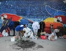Cuatro guacamayas rojas en vuelo y un turpial, el ave nacional de Venezuela, son motivos estrella en la obra. AFP/F. Parra