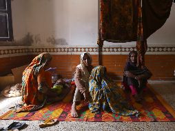 Varias personas descansan en una escuela acondicionada como refugio en la provincia de Sindh. EFE/S. Akber