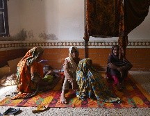 Varias personas descansan en una escuela acondicionada como refugio en la provincia de Sindh. EFE/S. Akber