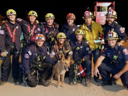 El orgulloso equipo de rescate posa con el perrito, que no presentó lesiones tras el accidente. AP/Departamento de Bomberos de Pasadena