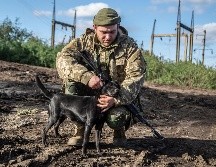 Un soldado ucraniano acaricia a un perro en el área recientemente recuperada de Izium. AP/O. Ratushniak
