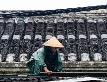 Un habitante refuerza el techo de su casa ante la inminente llegada de 