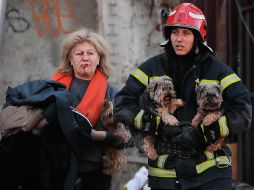 Un elemento de rescate ayuda a una mujer y a sus mascotas, que fueron afectados por el ataque ruso en Kiev, Ucrania. EFE / S. Dolzhenko