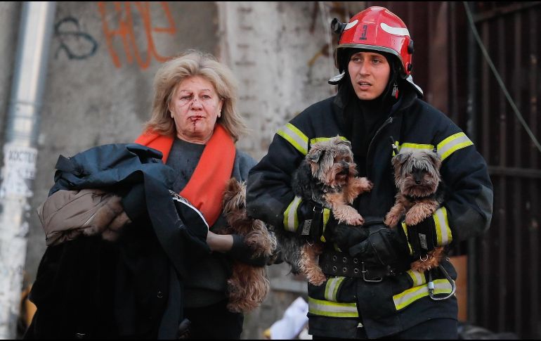 Un elemento de rescate ayuda a una mujer y a sus mascotas, que fueron afectados por el ataque ruso en Kiev, Ucrania. EFE / S. Dolzhenko