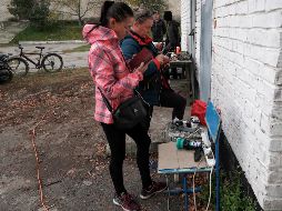 Residentes de Izium afectados por los bombardeos de este lunes recargan sus celulares en una estación móvil instalada por autoridades. EFE/A. Safadi